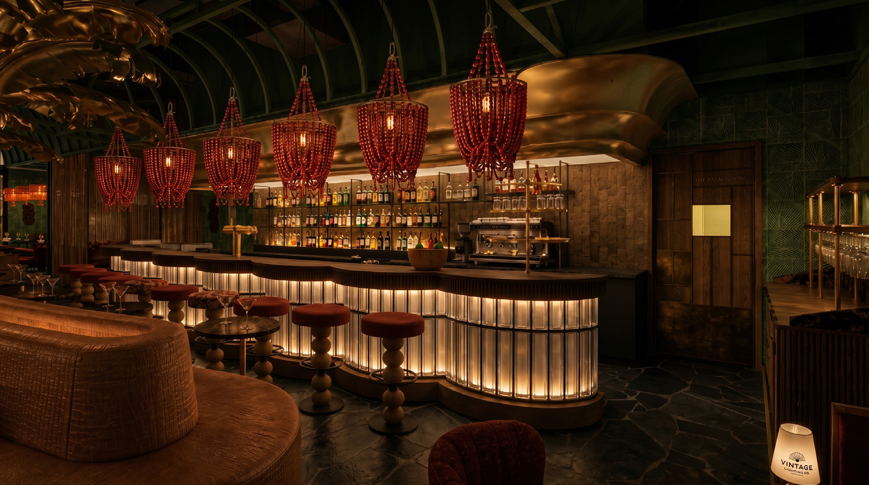The Oro Verde bar — coral chandeliers, brass palm details, and glowing bar in Abu Dhabi